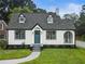 Charming home showcasing a blue front door, dormer windows, gray roof, and a neatly manicured lawn at 1283 Beecher Sw St, Atlanta, GA 30310