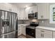 Modern kitchen featuring stainless steel appliances, white cabinets, and subway tile backsplash at 1283 Beecher Sw St, Atlanta, GA 30310