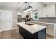 Modern kitchen featuring an island, stainless steel appliances, white cabinets, and stylish lighting at 1283 Beecher Sw St, Atlanta, GA 30310