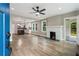 Open-concept living room with a fireplace, ceiling fan, hardwood floors, and an archway to another room at 1283 Beecher Sw St, Atlanta, GA 30310