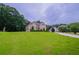 Beautifully landscaped home with a lush green lawn and mature trees at 157 Hambrick Dr, Stockbridge, GA 30281