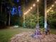 Cozy backyard fire pit area with stone patio and string lights strung between the trees at 2630 Timler Trce, Snellville, GA 30078