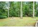Spacious backyard with a fire pit area, mature trees, and a swing set at 2630 Timler Trce, Snellville, GA 30078