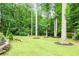 Expansive backyard featuring mature trees, a swing set, and space for outdoor activities at 2630 Timler Trce, Snellville, GA 30078