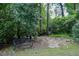 A tranquil backyard view of a bench beside a stone path winding through the trees at 2630 Timler Trce, Snellville, GA 30078