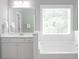 Stylish bathroom with white cabinetry, a large window, and a soaking tub at 2630 Timler Trce, Snellville, GA 30078
