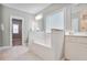 Bathroom featuring a built-in tub with tile surround, bright lighting, and storage vanity at 2630 Timler Trce, Snellville, GA 30078