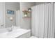 Cozy bathroom with neutral tones, wood shelves, framed art, and a combination shower and tub at 2630 Timler Trce, Snellville, GA 30078