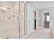 Tiled bathroom showcasing a glass-enclosed shower, storage, and neutral tones for a clean aesthetic at 2630 Timler Trce, Snellville, GA 30078