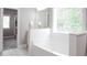 Bright bathroom featuring a soaking tub and a view of the closet at 2630 Timler Trce, Snellville, GA 30078