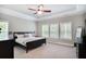 Spacious bedroom featuring tray ceiling, ceiling fan, and bright natural light through multiple windows at 2630 Timler Trce, Snellville, GA 30078