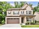 Charming two-story home with a brick and beige facade, featuring a well-manicured lawn and a two-car garage at 2630 Timler Trce, Snellville, GA 30078