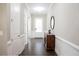 Bright hallway with dark wood floors, white trim, and a decorative table with a mirror at 2630 Timler Trce, Snellville, GA 30078