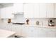Bright kitchen with white cabinets, stainless steel range hood, and stylish countertops at 2630 Timler Trce, Snellville, GA 30078