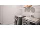Efficient laundry room features a modern washer and dryer, plus ample shelving for storage at 2630 Timler Trce, Snellville, GA 30078