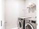 Laundry room with front load machines, wire shelving, and door at 2630 Timler Trce, Snellville, GA 30078