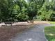 Community playground featuring climbing structures and a bench, surrounded by lush trees and greenery at 2630 Timler Trce, Snellville, GA 30078