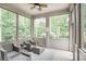 Relax in this screened porch with wooded views, comfortable seating, and a ceiling fan at 2630 Timler Trce, Snellville, GA 30078