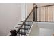 Elegant staircase with dark wood steps and wrought iron balusters in a neutral-toned home at 2630 Timler Trce, Snellville, GA 30078