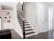 Elegant staircase with dark wood steps and a white door, alongside built-in shelving at 2630 Timler Trce, Snellville, GA 30078