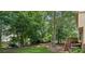 Lush backyard with mature trees, grassy lawn, and a wooden deck on a multi-level home at 3267 Remembrance Trce, Lawrenceville, GA 30044