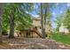 Backyard view of a multi-level home with wooden deck, surrounded by trees and a grassy lawn at 3267 Remembrance Trce, Lawrenceville, GA 30044