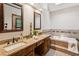 Bathroom with double sinks, granite counters, and a soaking tub with tile surround at 3267 Remembrance Trce, Lawrenceville, GA 30044