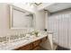 Bathroom vanity featuring granite countertops, wood cabinets, and a decorative mirror at 3267 Remembrance Trce, Lawrenceville, GA 30044