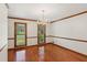 Formal dining room with hardwood floors, chandelier, and natural light from the windows at 3267 Remembrance Trce, Lawrenceville, GA 30044