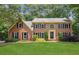 Classic brick home with a lush green lawn, mature trees, and manicured landscaping at 3267 Remembrance Trce, Lawrenceville, GA 30044