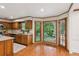 Well-lit kitchen featuring wood cabinets, granite countertops, and a large window with backyard views at 3267 Remembrance Trce, Lawrenceville, GA 30044