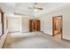A carpeted main bedroom featuring a tray ceiling and doorways to other rooms at 3267 Remembrance Trce, Lawrenceville, GA 30044