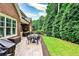 Paver patio with dining set and grill, lush lawn and sculpted foliage and green fence-line landscaping at 1250 Atherton Park, Roswell, GA 30076