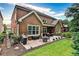 Brick home featuring a patio with dining and sitting space, green grass, and professional landscaping at 1250 Atherton Park, Roswell, GA 30076