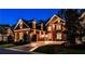 Stunning two-story brick home with a manicured lawn and a three-car garage at twilight at 1250 Atherton Park, Roswell, GA 30076