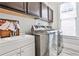 Modern laundry room with stainless steel washer and dryer, sink, and storage cabinets at 1250 Atherton Park, Roswell, GA 30076