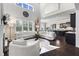 Open-concept living room with tall windows, fireplace, and a view of the kitchen with black cabinets at 1250 Atherton Park, Roswell, GA 30076