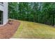 Landscaped backyard featuring mature trees and lush grass at 12995 Bucksport Dr, Roswell, GA 30075