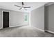 Bright, neutral bedroom featuring a ceiling fan and a window with a wooded view at 12995 Bucksport Dr, Roswell, GA 30075