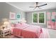 Bright bedroom features a ceiling fan, window and pink decor at 12995 Bucksport Dr, Roswell, GA 30075