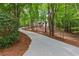 Scenic driveway leading to a secluded home through lush greenery and mature trees at 12995 Bucksport Dr, Roswell, GA 30075