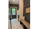 Inviting entryway with stylish tile flooring, mudroom bench, custom wall paneling, and convenient access to the outdoors at 12995 Bucksport Dr, Roswell, GA 30075