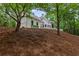 Beautifully landscaped front yard on a sloped lot with view of the home's elevation at 12995 Bucksport Dr, Roswell, GA 30075