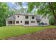 A rear exterior view of a two-story home with a well-manicured lawn at 12995 Bucksport Dr, Roswell, GA 30075