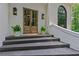 Elegant front door with sidelights and planters creates an inviting entryway at 12995 Bucksport Dr, Roswell, GA 30075