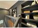 Hallway featuring built-in dark shelving, crown molding, and a view of the staircase at 12995 Bucksport Dr, Roswell, GA 30075