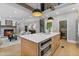 Gourmet kitchen featuring a central island with seating, custom cabinets, stainless steel appliances, and a seamless transition to the living space at 12995 Bucksport Dr, Roswell, GA 30075