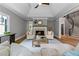 Inviting living room featuring a fireplace, tray ceiling, and access to a curved staircase at 12995 Bucksport Dr, Roswell, GA 30075