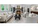 Well-lit living room with a stone fireplace, neutral color scheme, and stylish seating at 12995 Bucksport Dr, Roswell, GA 30075