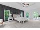 Bright main bedroom featuring an accent wall, large windows with wooded views, and plush carpeting for a cozy feel at 12995 Bucksport Dr, Roswell, GA 30075